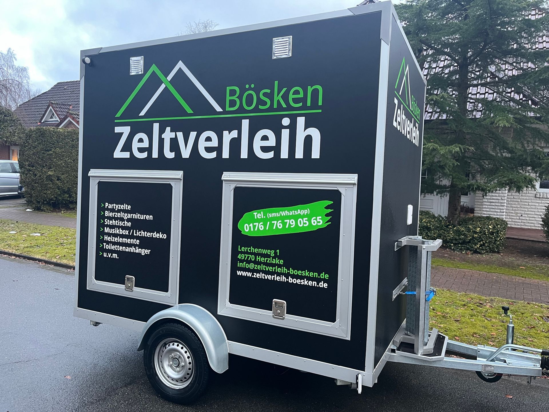Ein schwarzer Anhänger mit der Aufschrift „Bösken Zeltverleih“ und Kontaktinformationen stand auf der Straße.