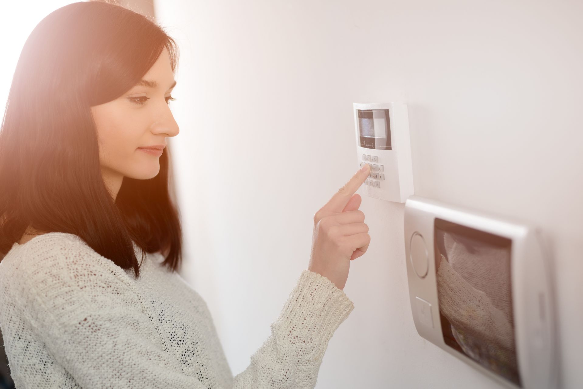 a woman typing on a home security system keypad