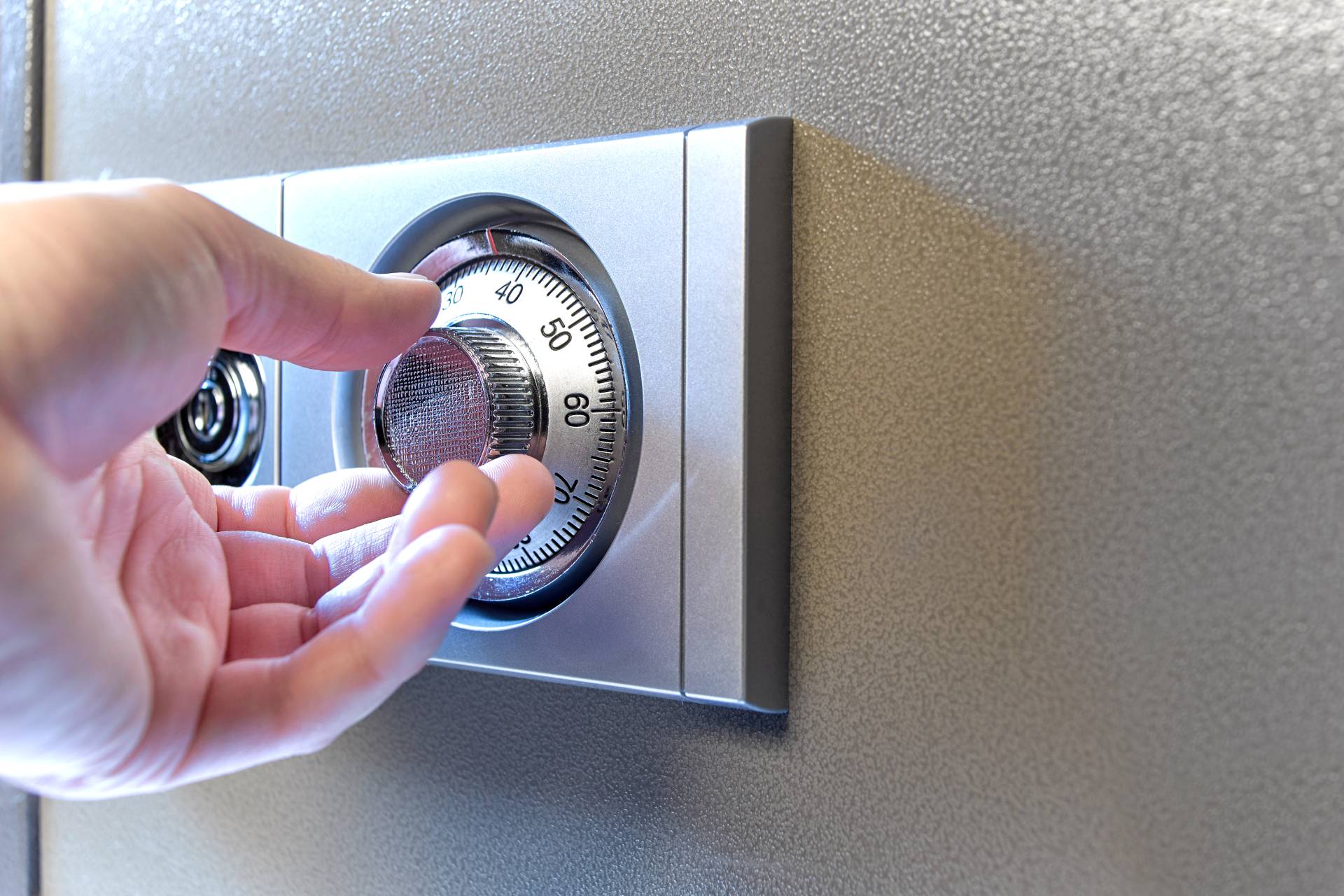 a person turning a safe lock combination
