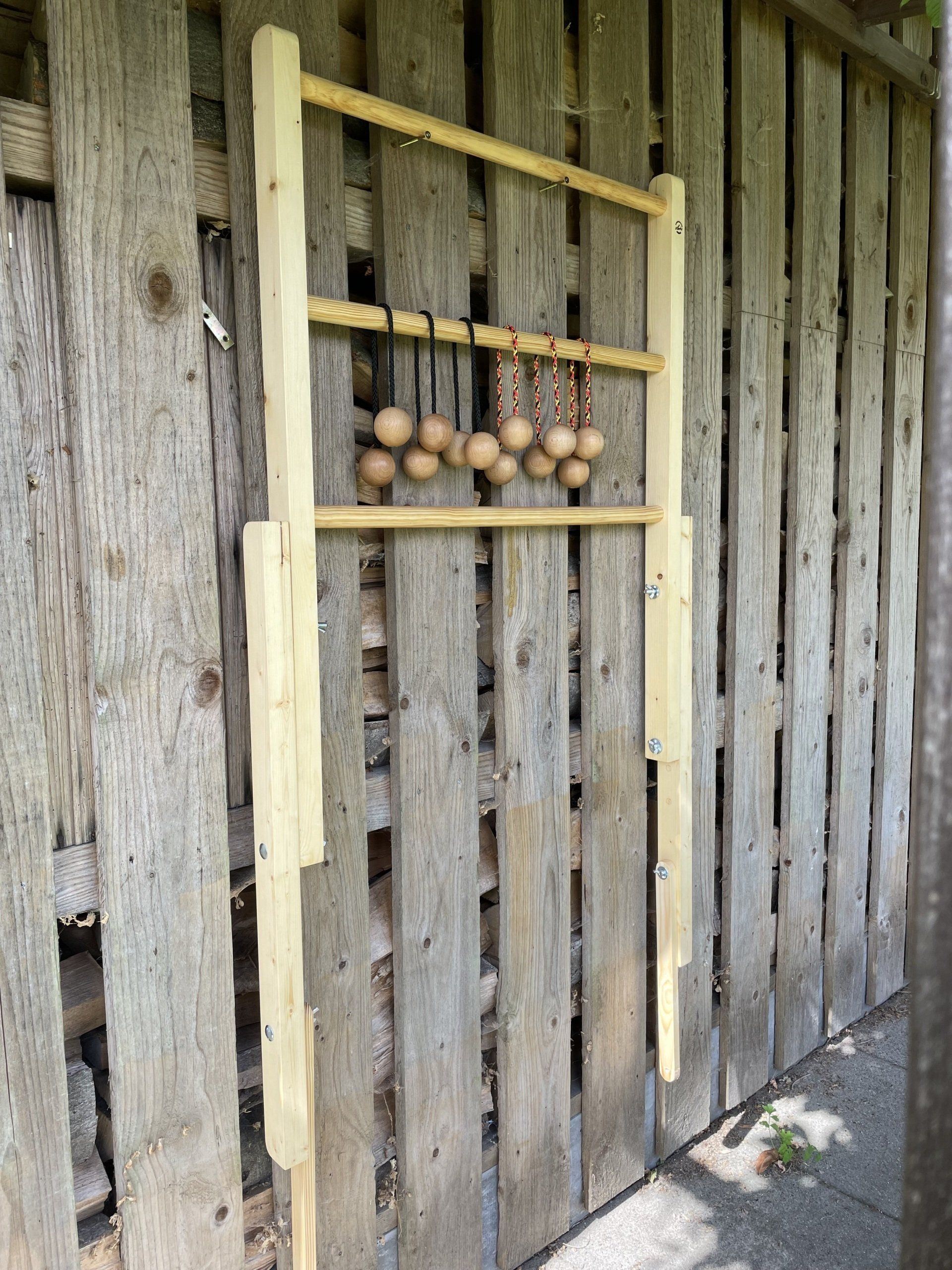Outdoorspiel: Handgefertigtes Gesellschaftsspiel „Leitergolf” für draußen, platzsparend befestigt an einer Holzwand