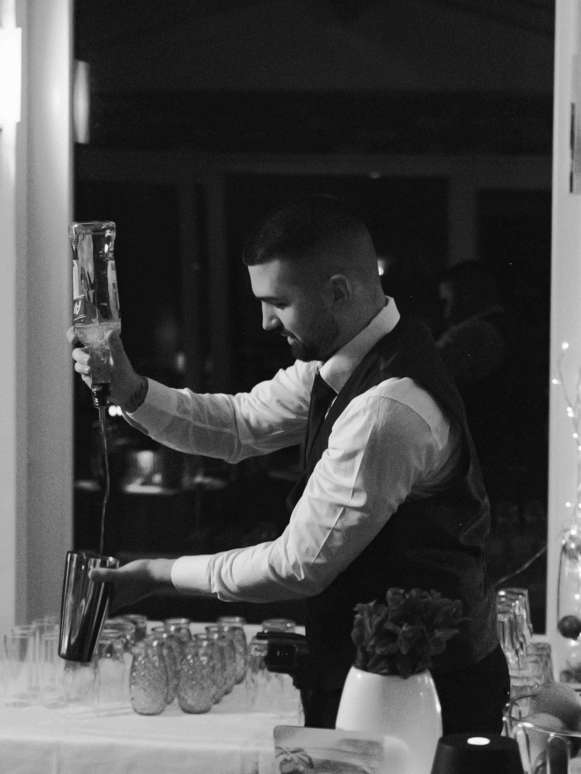 Profesioneller Barkeeper der Flüssigkeit ausschenkt für ein besonderes Firmen-Event