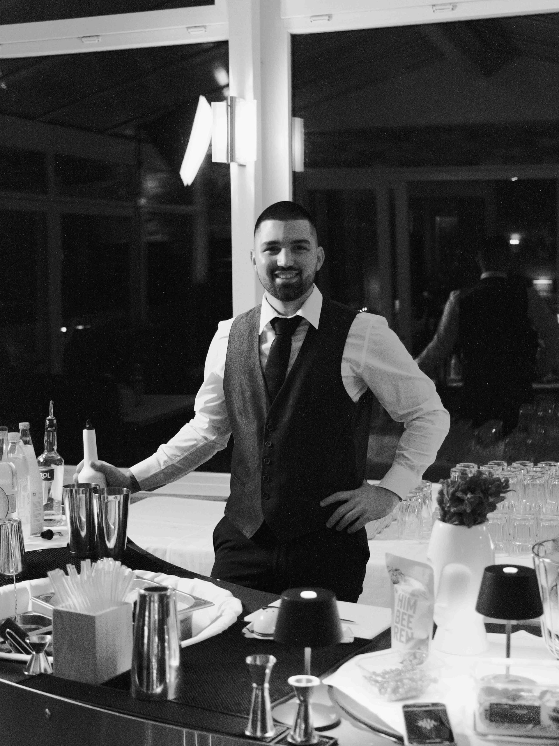 lachender Barkeeper im Smoking für eine edle Veranstaltung