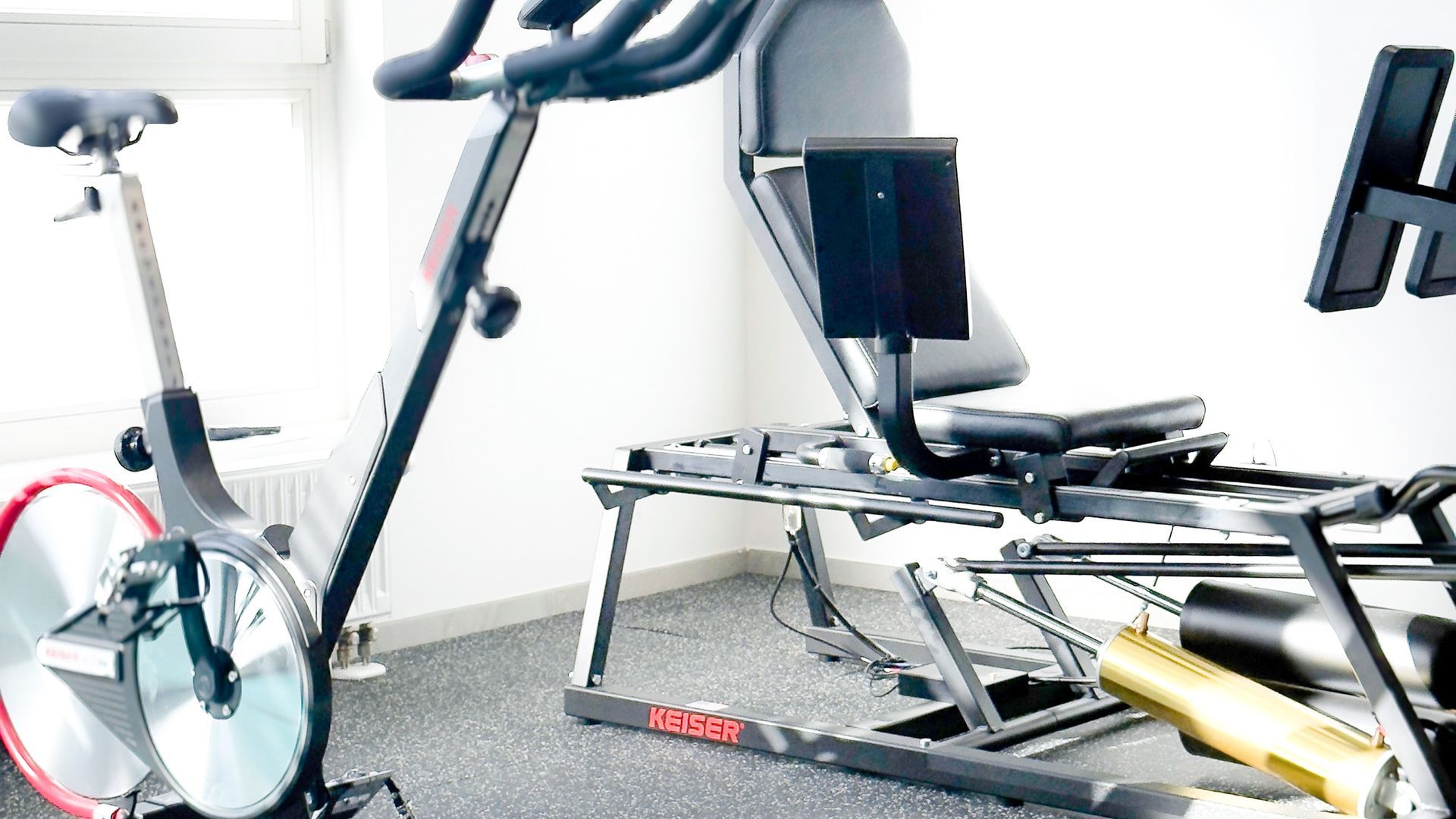 Hydraulische Beinpresse und Keiser-Ergometer im Trainingsraum der Physiopraxis be.Physio in Ottobrunn – gezieltes Training für Rehabilitation und Muskelaufbau