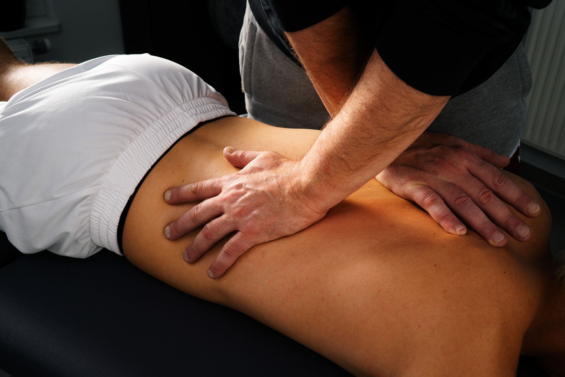Physiotherapeut führt manuelle Therapie an der Wirbelsäule eines Patienten durch – gezielte ganzheitliche Behandlung bei be.Physio in Ottobrunn