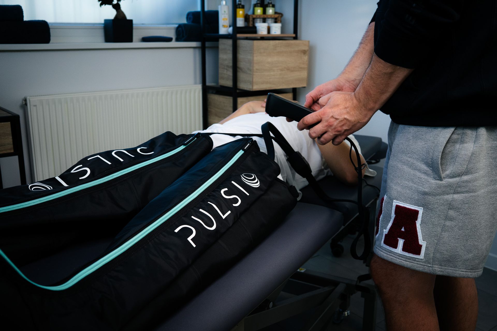 Physiotherapeut bringt Kinesio-Tape auf ein schmerzhaftes Knie auf – gezielte Entlastung und Unterstützung im Rahmen der physikalischen Therapie bei be.Physio Ottobrunn.