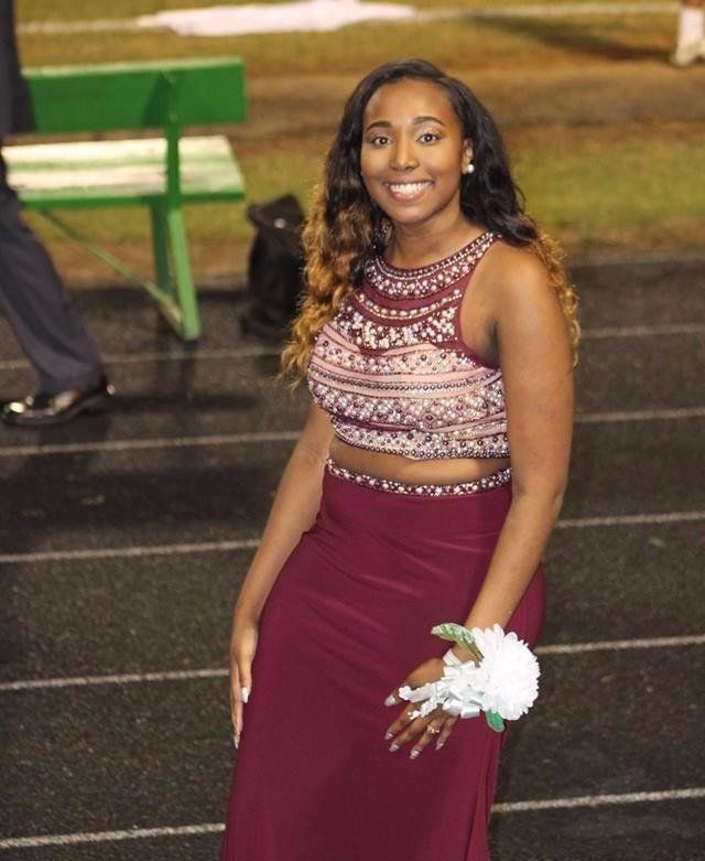 Girl in a prom dress on a football field