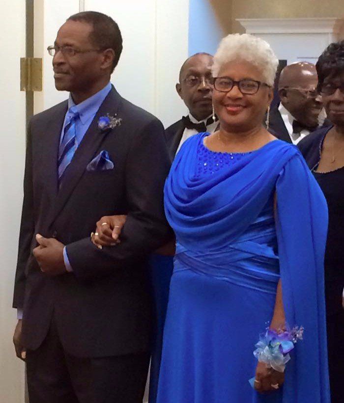 Woman in blue dress next to a man in a tux