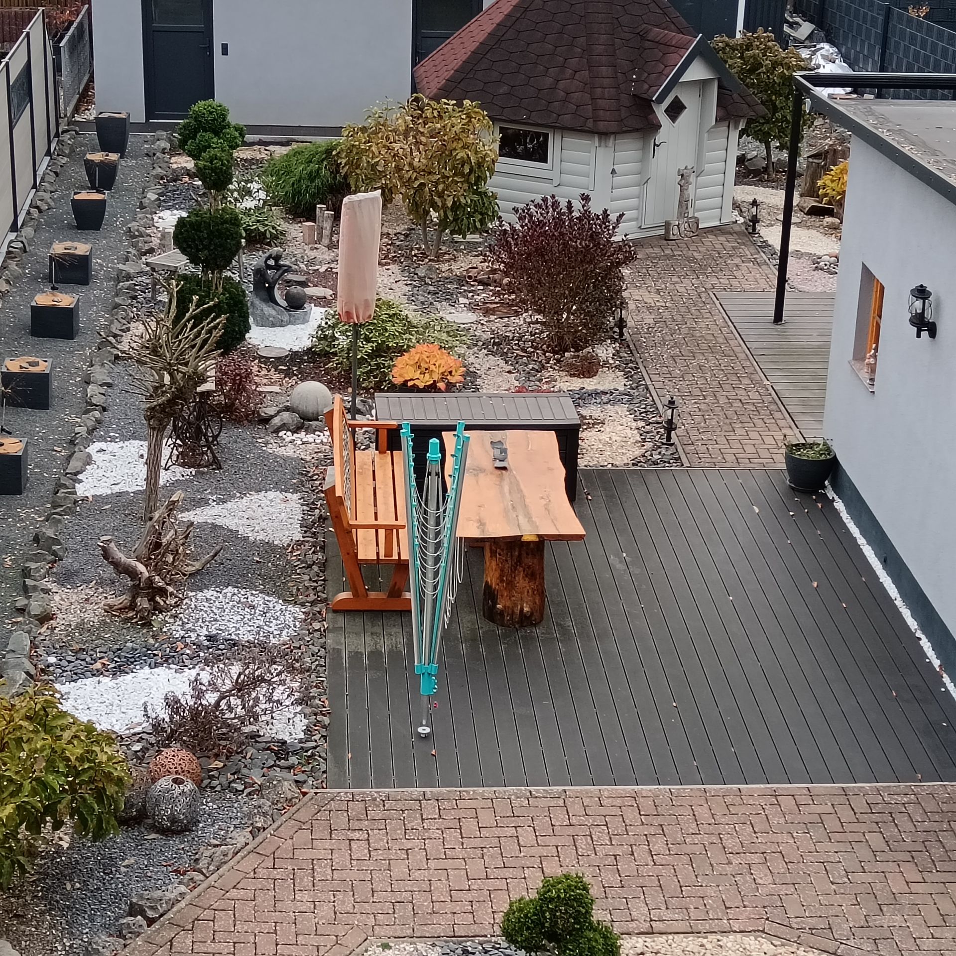 Terrasse mit Holzmöbeln, Gartengestaltung und einem kleinen Steingarten