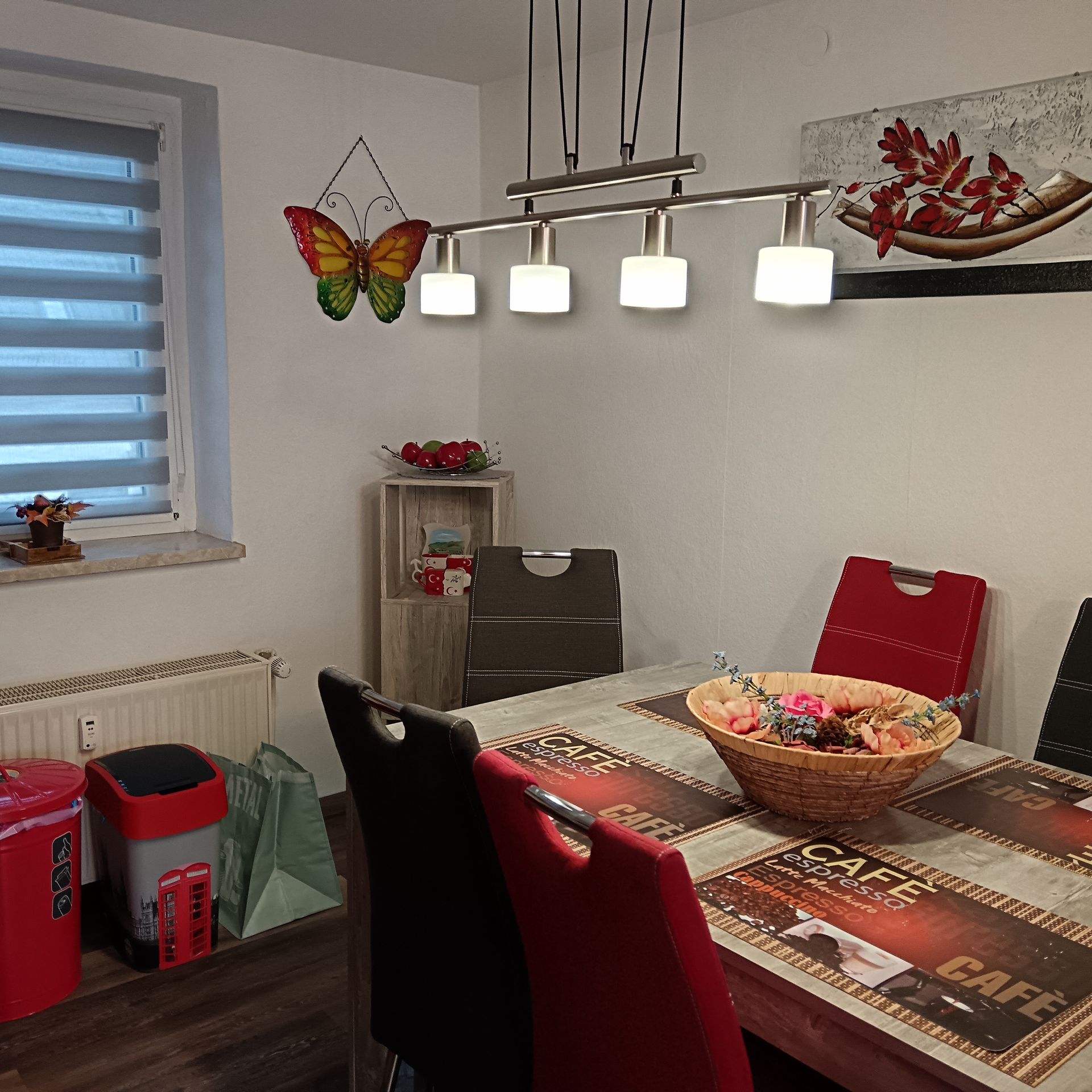 Esszimmer mit Tisch, Stühlen, Kunstwerken und einer Schmetterlingsdekoration.