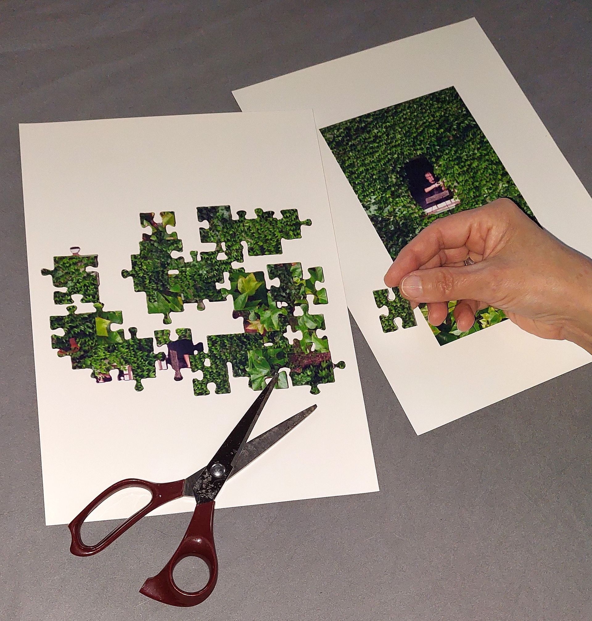 Blick durchs Fenster als Durchblick Ein Puzzle mit Vorlage, eine Schere und eine Hand mit einem Puzzleteil.