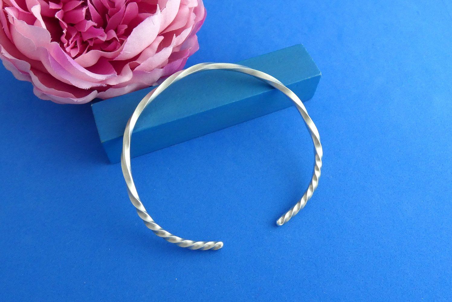 offener Armreif aus Argentium-Sterlingsilber, geschmiedet aus Vierkantdraht, der im zentralen Bereich wenig, zu den Enden hin stark verdreht wurde