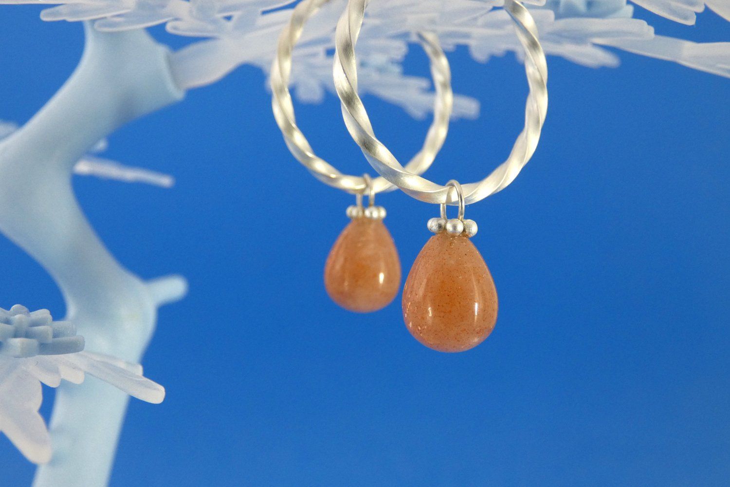 Creolen, die keiner Ohrlöcher bedürfen, gefertigt aus gedrehtem Vierkantdraht aus Argentium-Sterlingsilber, mit Anhängern aus lachsfarbenen, schimmernden Sonnenstein-Perlen