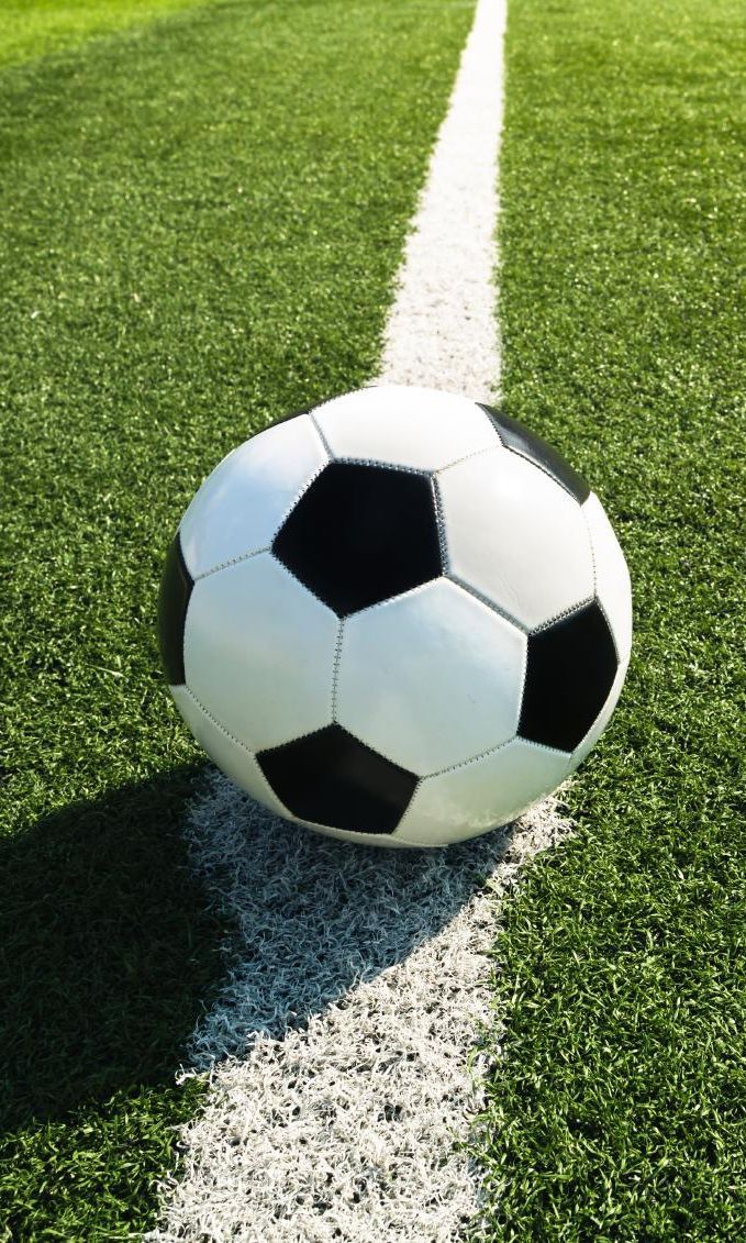 Fußball auf einer weißen Spielfeldlinie auf grünem Rasen