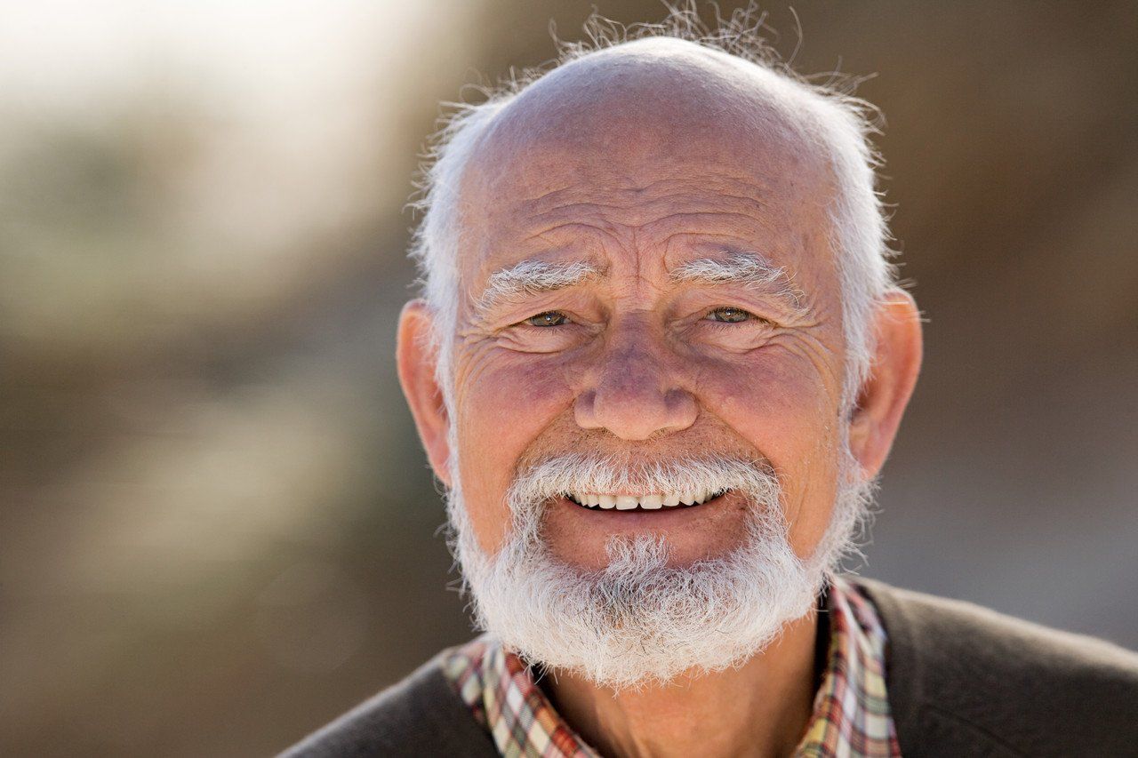 Grey haired, smiling senior citizen.