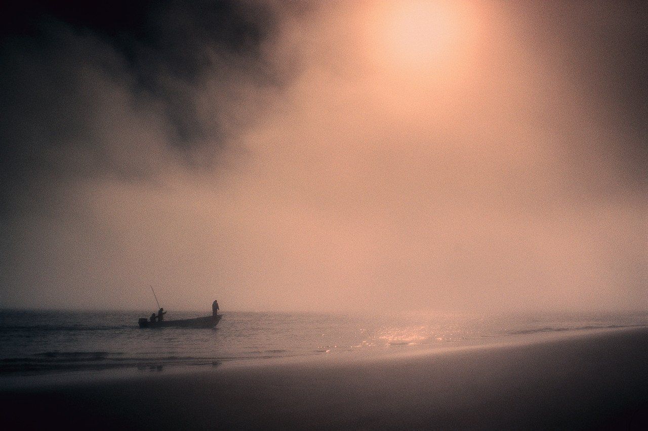 Men in a fishing boat, on a misty day,