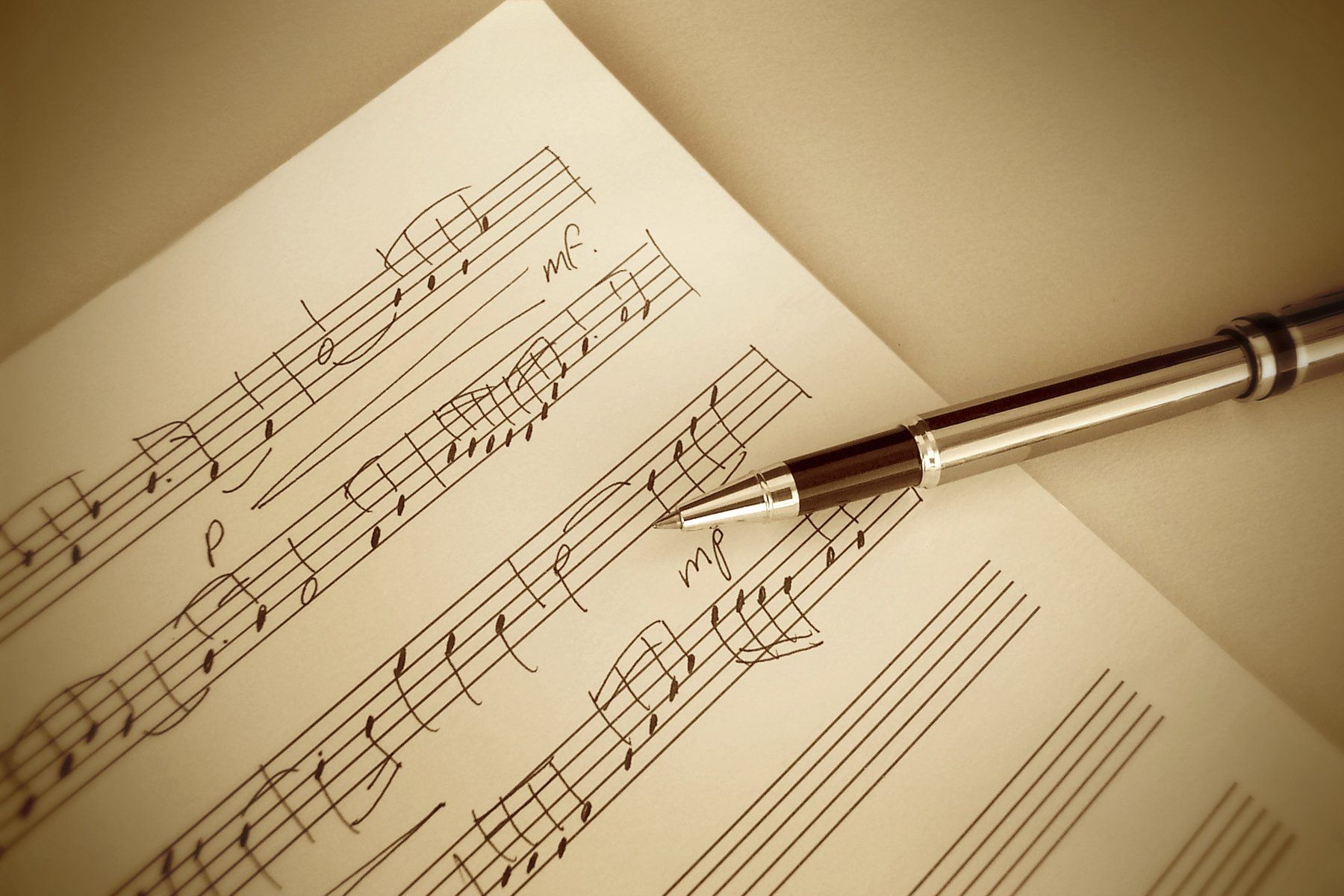 Notenblatt mit einem Stift, soll das Schreiben von eigener Musik symbolisieren