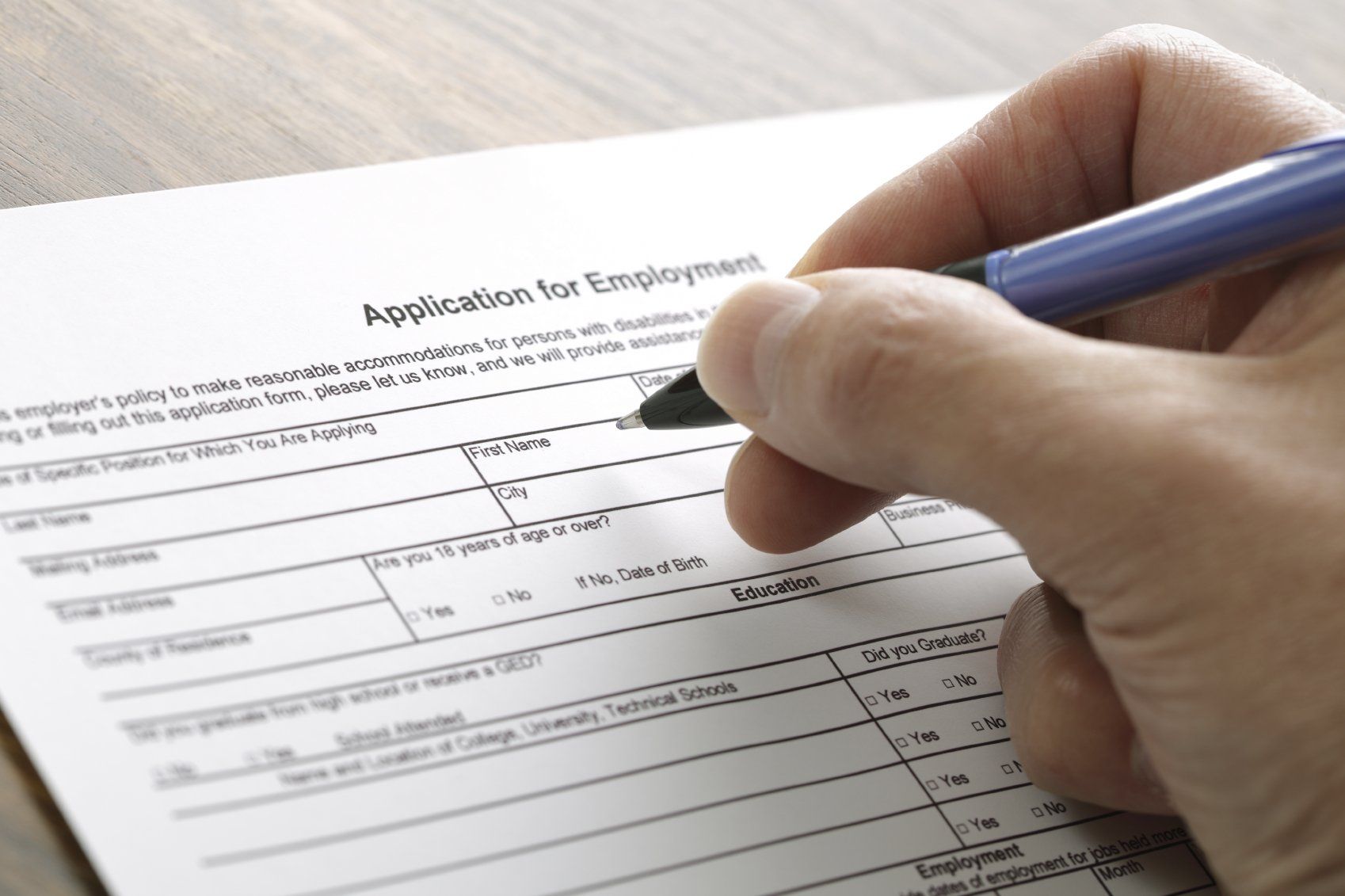 Graphic of someone holding a pen filling out a form