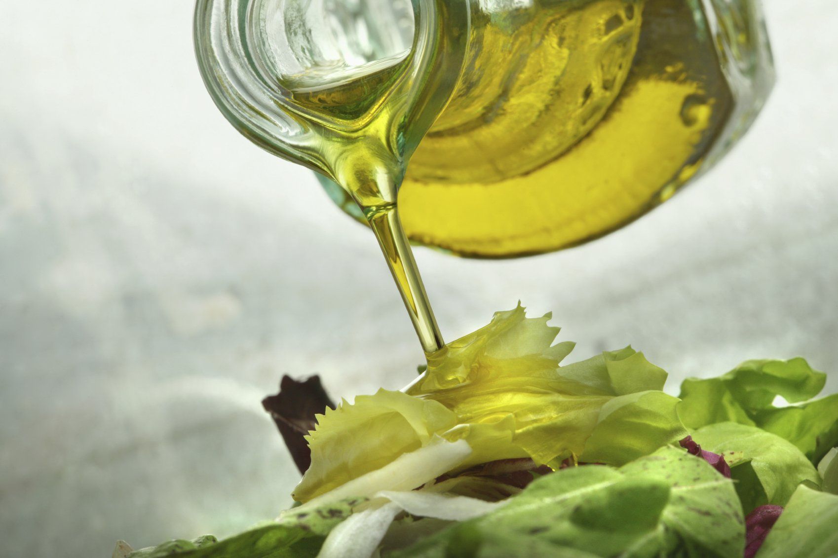 photo of oil pouring onto a salad