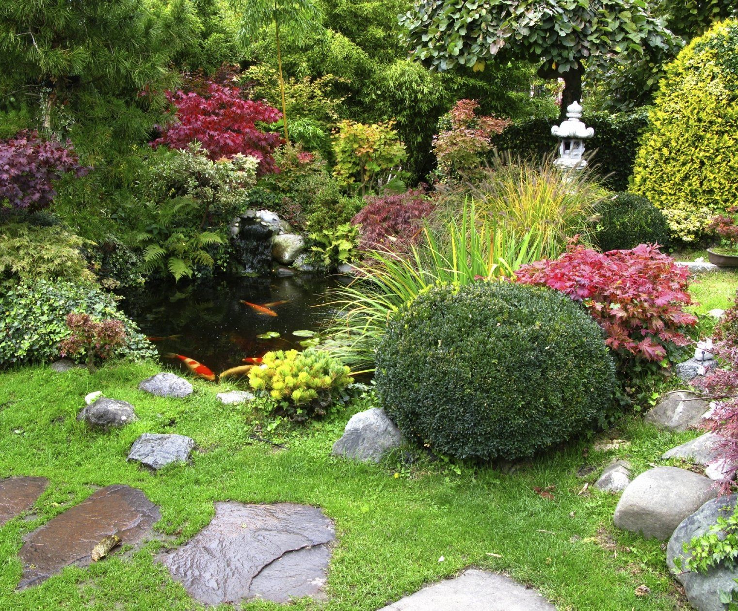 A beautiful flower garden with a gold fish pond.
