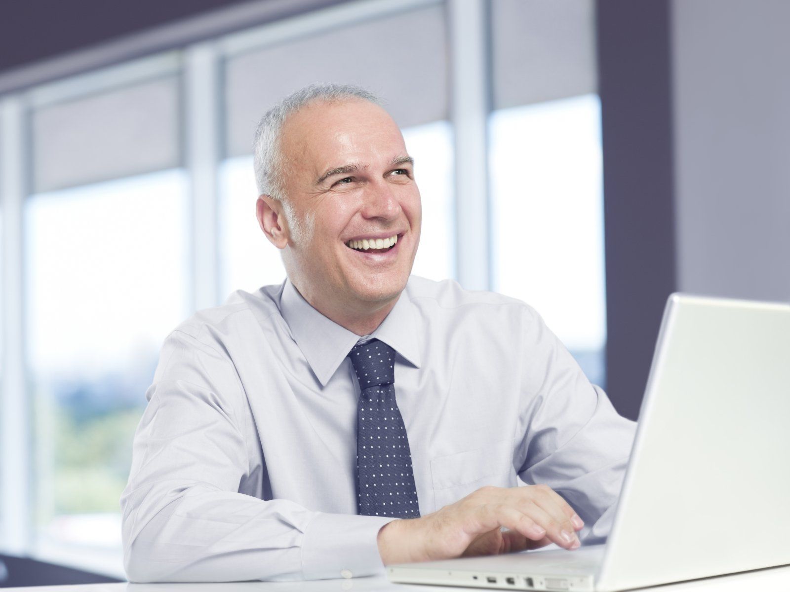 A senior citizen using his laptop to search for post-retirement job.