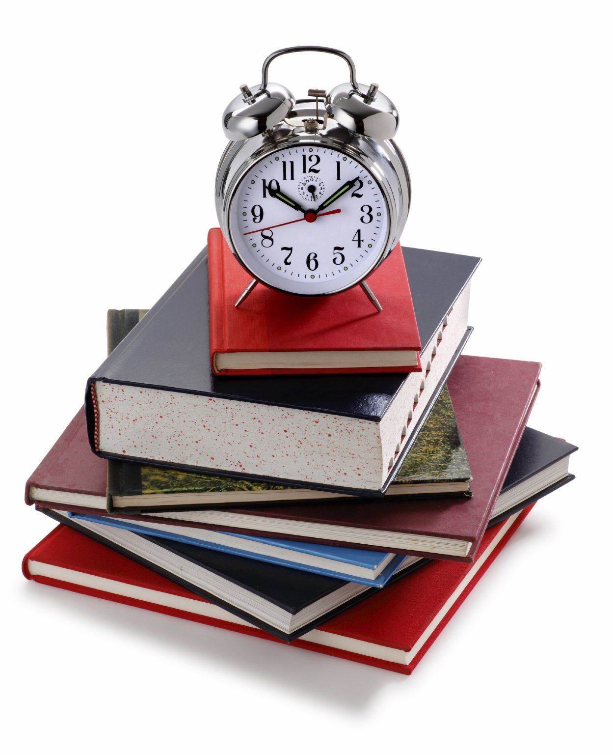 A double-bell, traditional alarm clock sitting on a stack of colorful books.