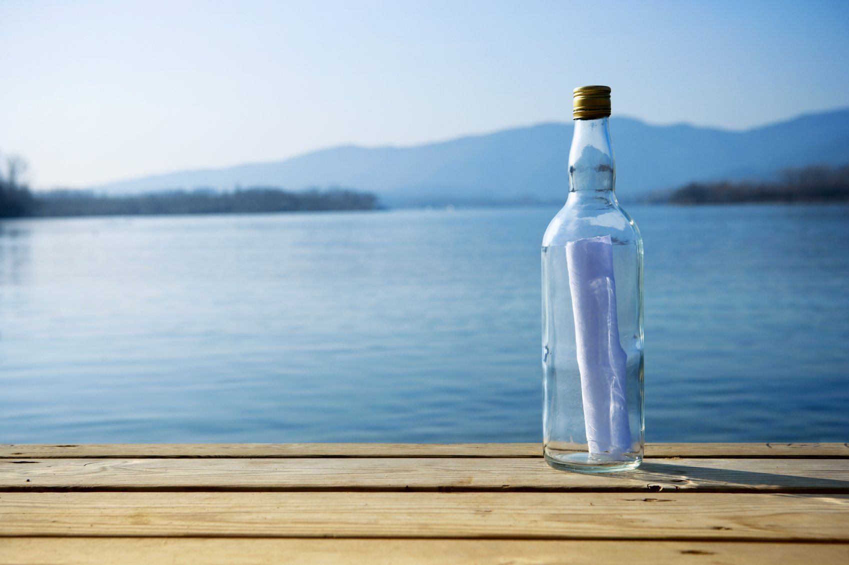 Flaschenpost auf Steg am Wasser