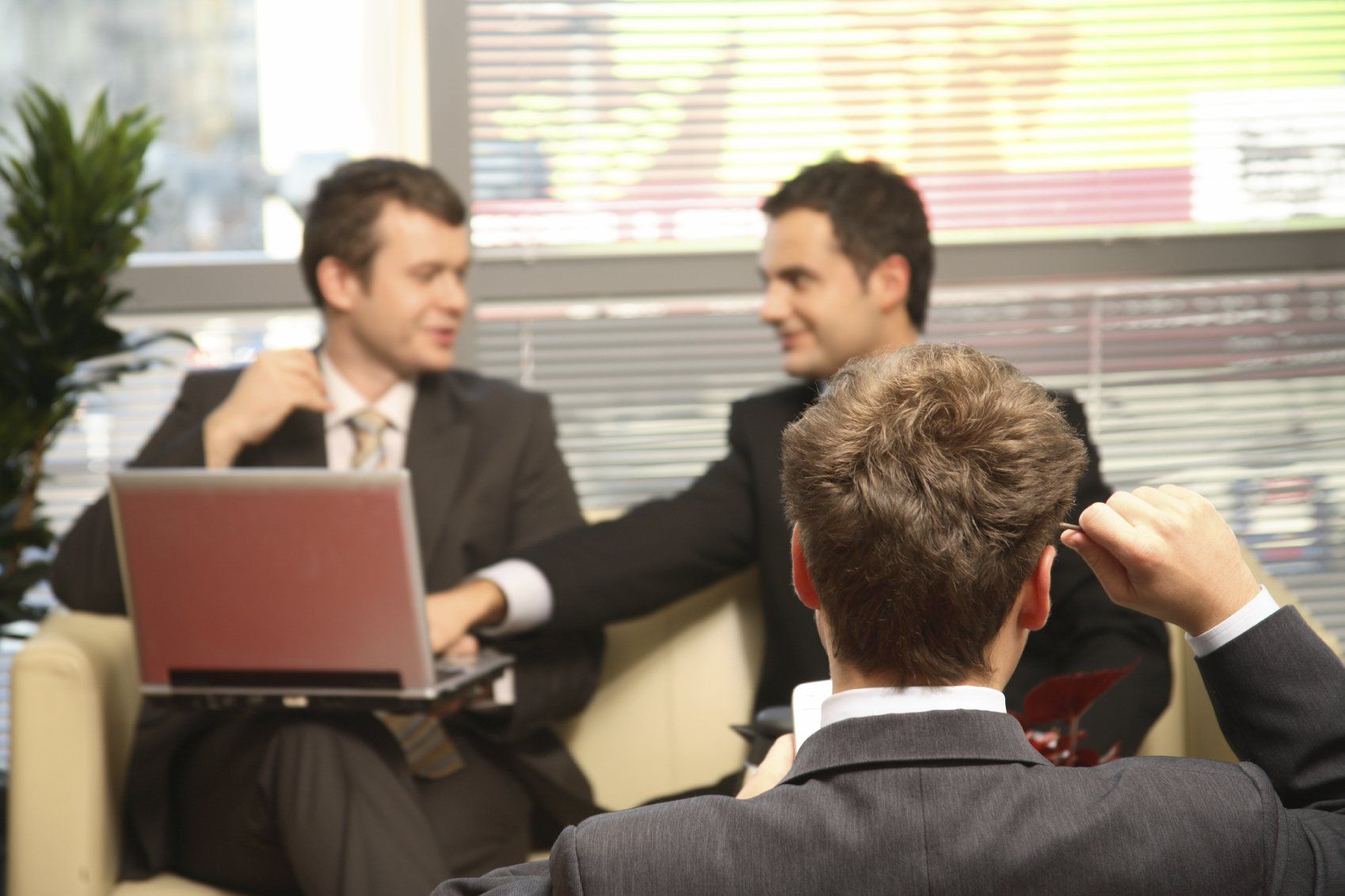 Three, young business employees discussing their continuing education plans.