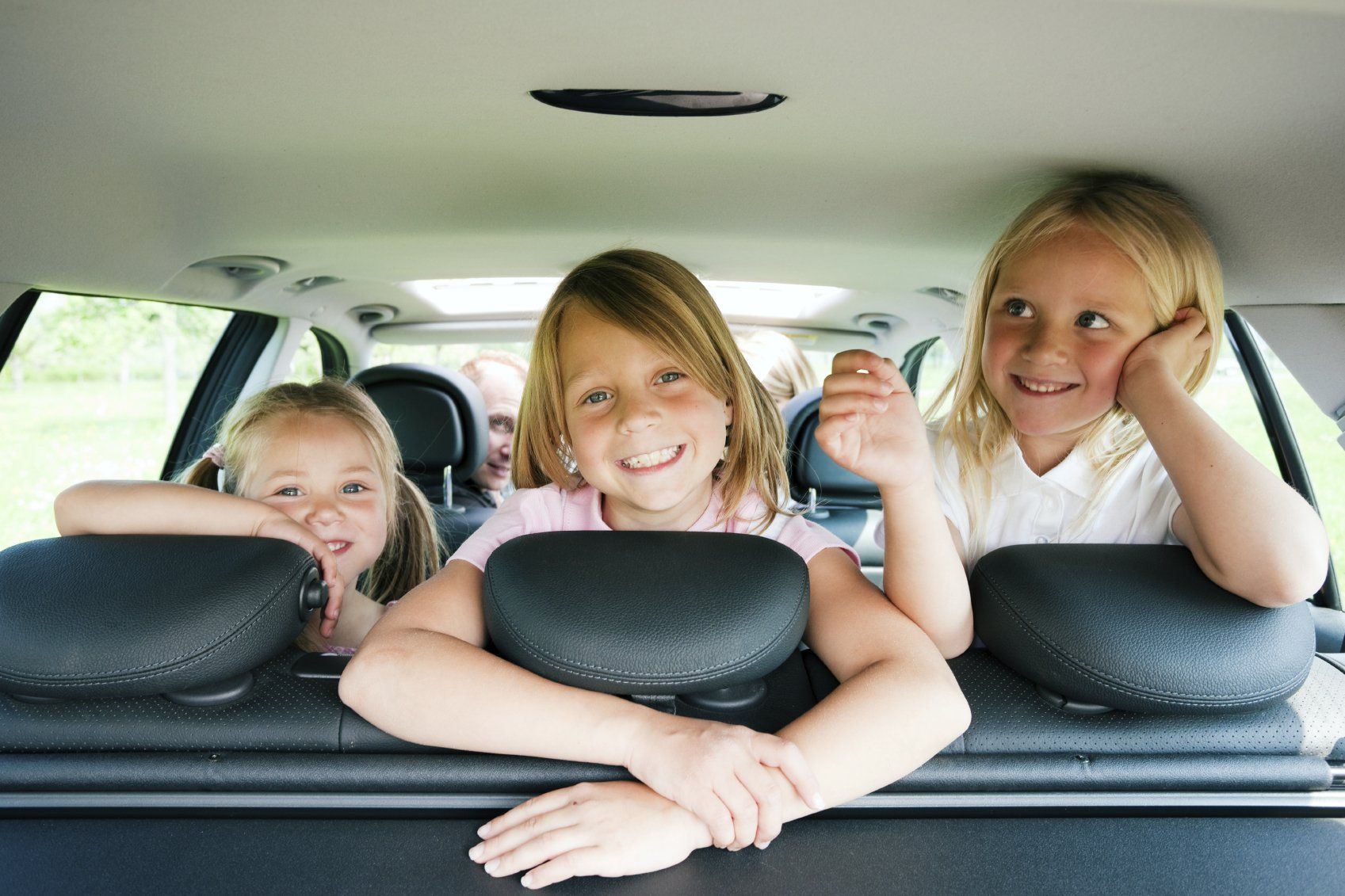 Drei Kinder auf dem Rücksitz eines Wagens