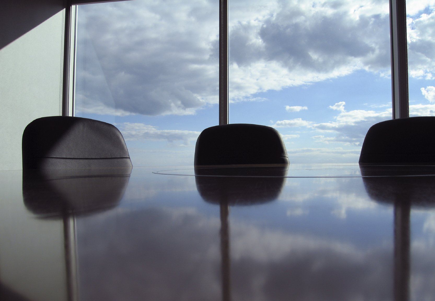 Picture of office chairs in front of window with sky in background