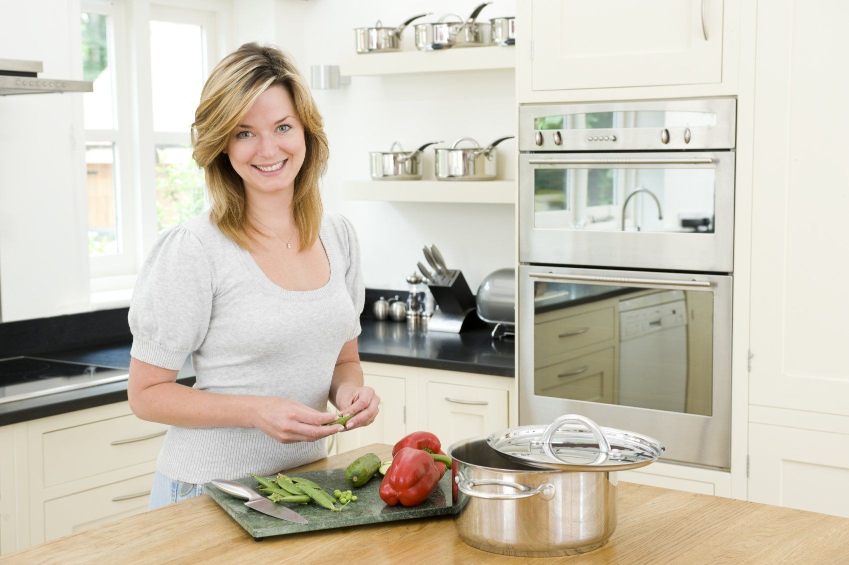 A young lady preparing vegetables at home.