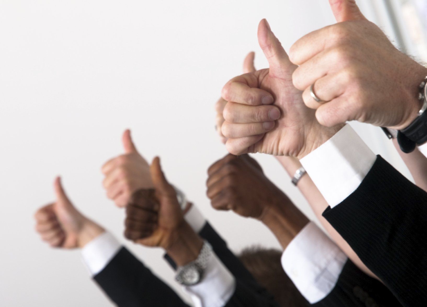 Three businesspersons showing thumbs up