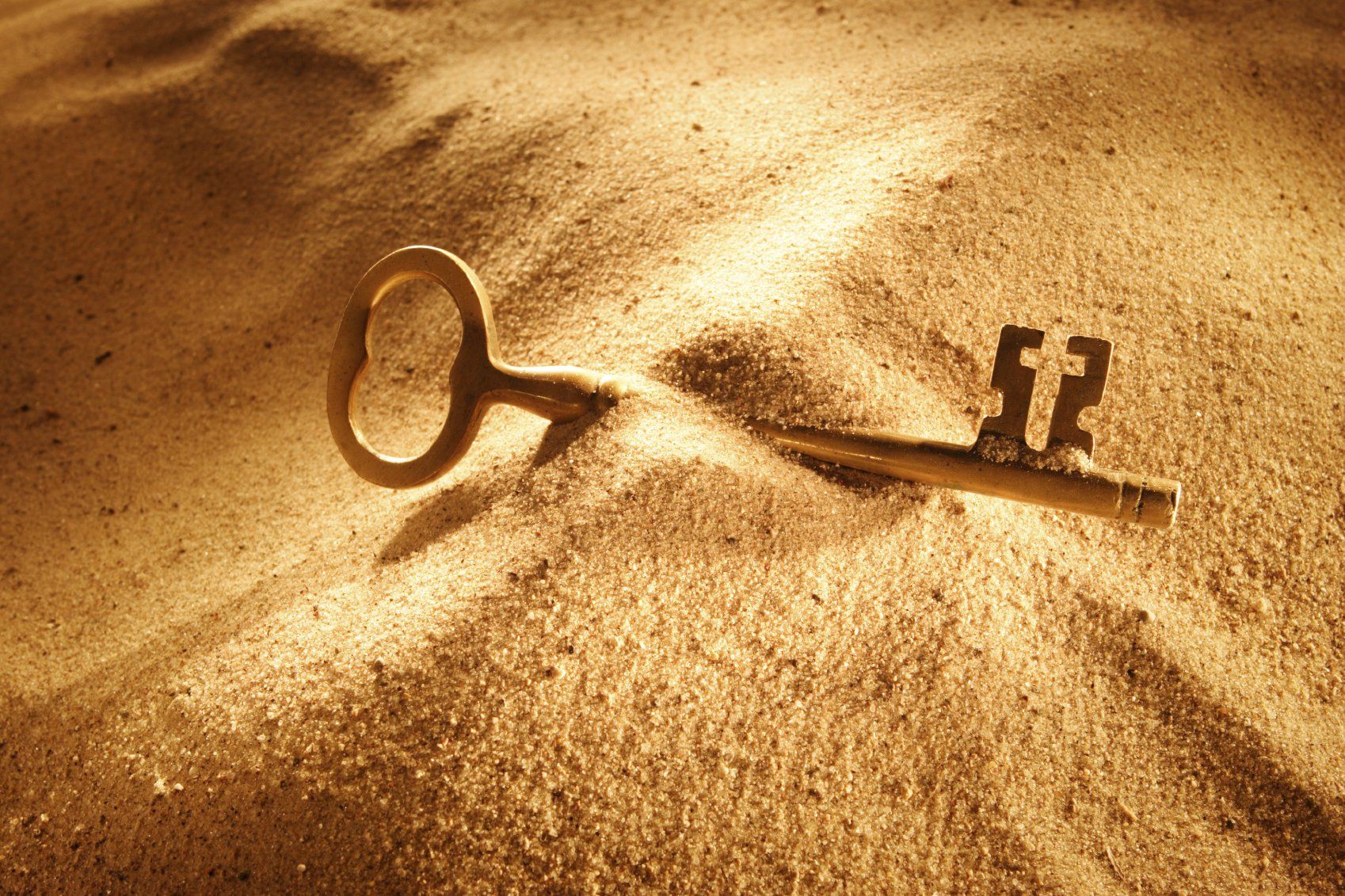 Goldener Schlüssel im Sand
