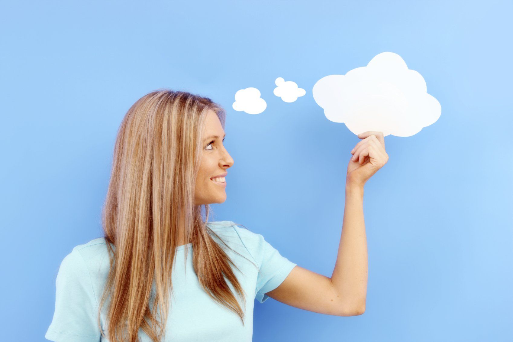 Eine Frau hält eine Gedanken-Wolke - als Sinnbild für ein positives Mindset