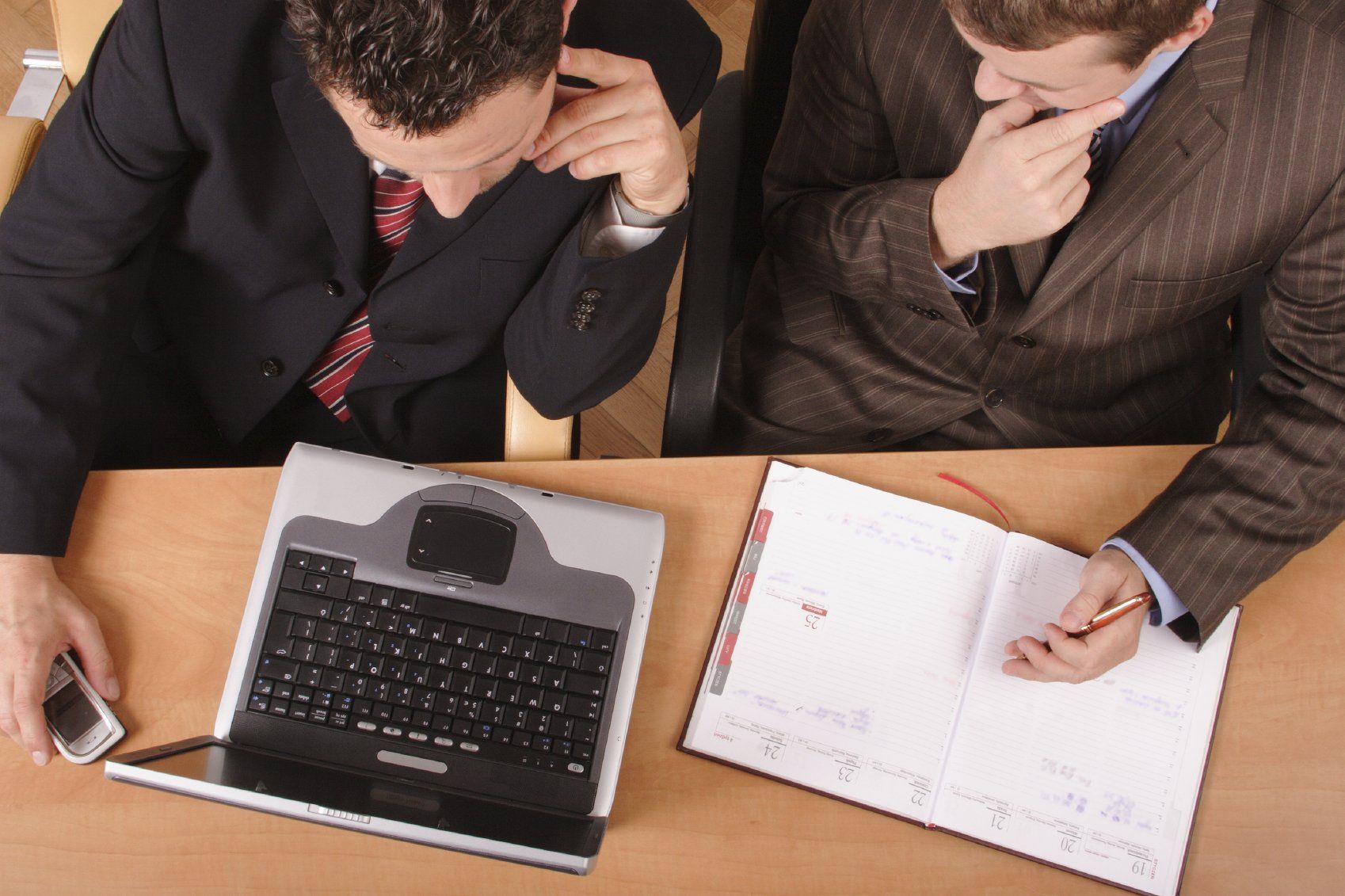 Two business colleagues discussing business over a laptop