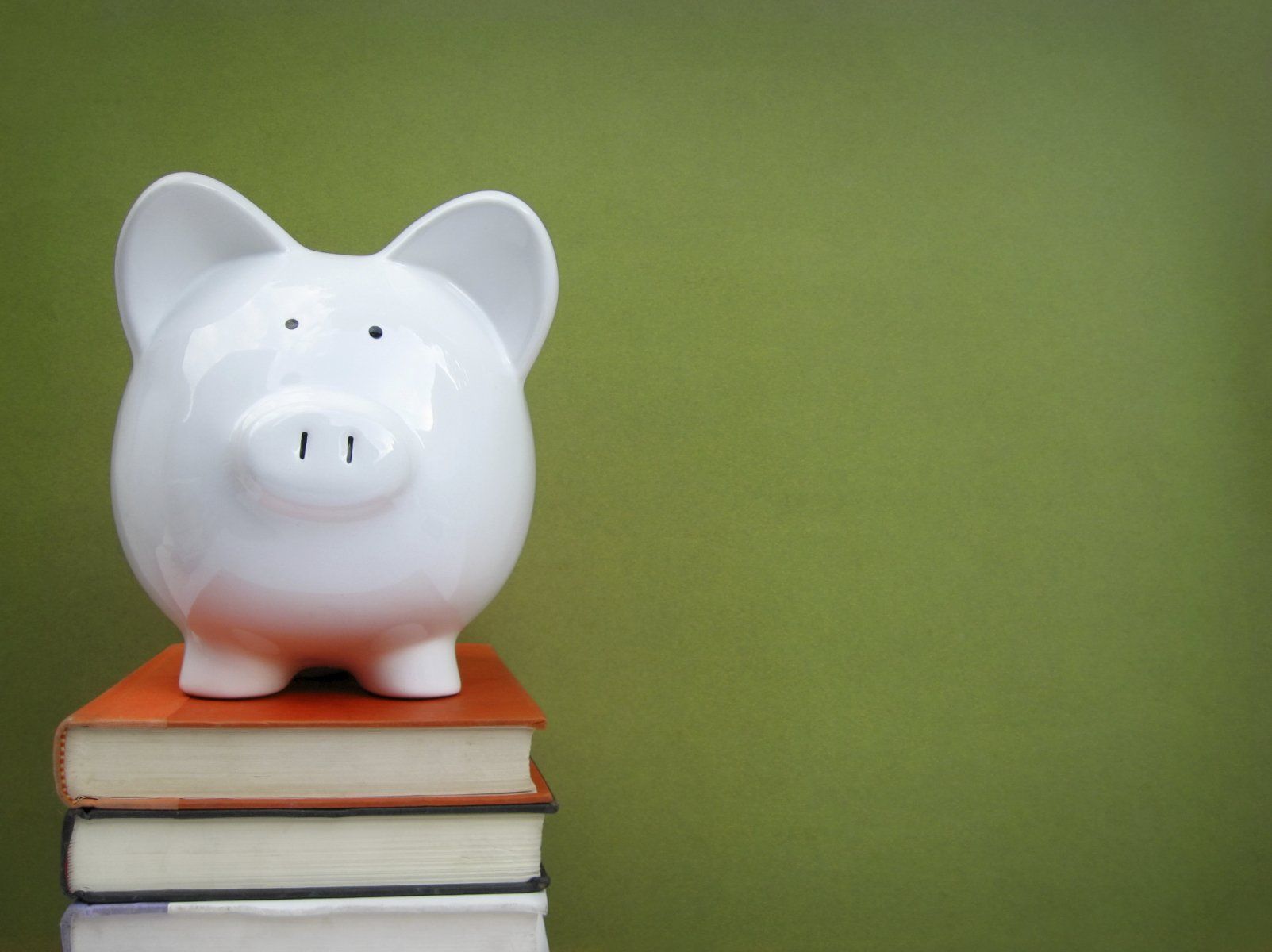 image of piggy bank sitting on a stack of books