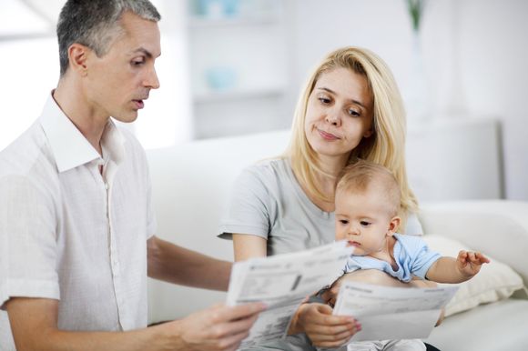 personal debt advice - couple and a baby looking at their bills looking worried