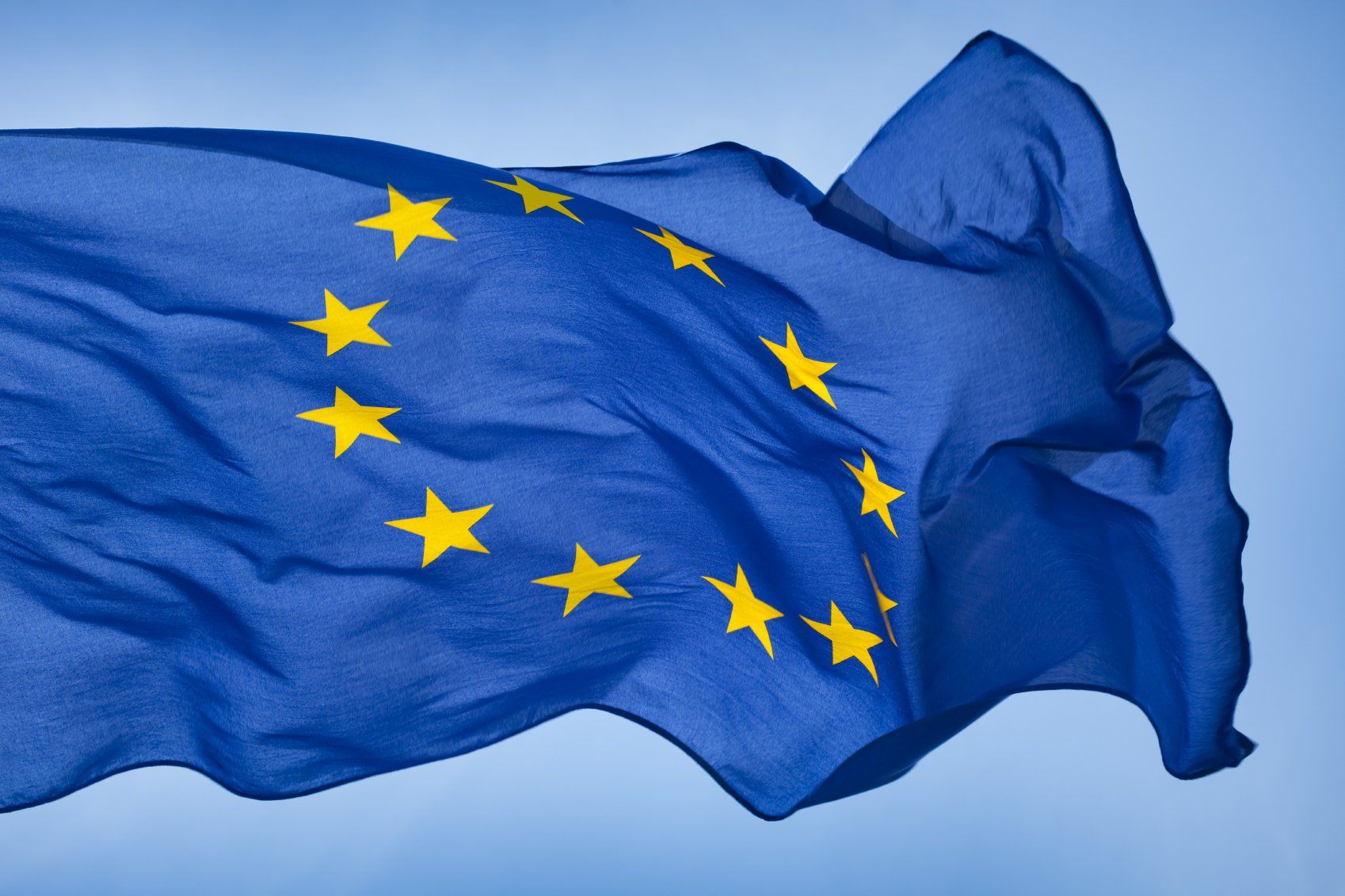 Die Flagge der Europäischen Union, ein Kreis aus zwölf goldenen Sternen auf blauem Hintergrund, weht im Wind des italienischen Handelsrecht