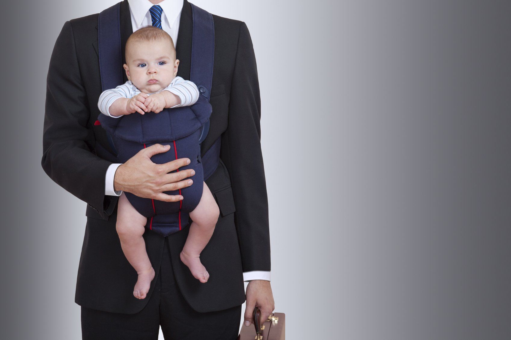 Mann mit Baby und Aktentasche im Spannungsfeld der work-life-balance