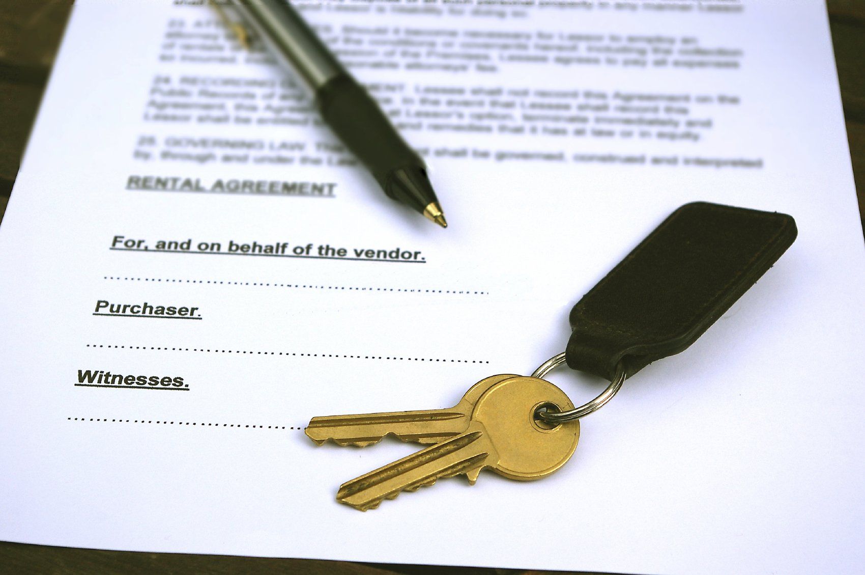 Ein Schlüsselbund einer italienischen Immobilie liegt auf einem Mietvertragsdokument, daneben ein Stift für die Unterzeichnung eines Notarvertrages