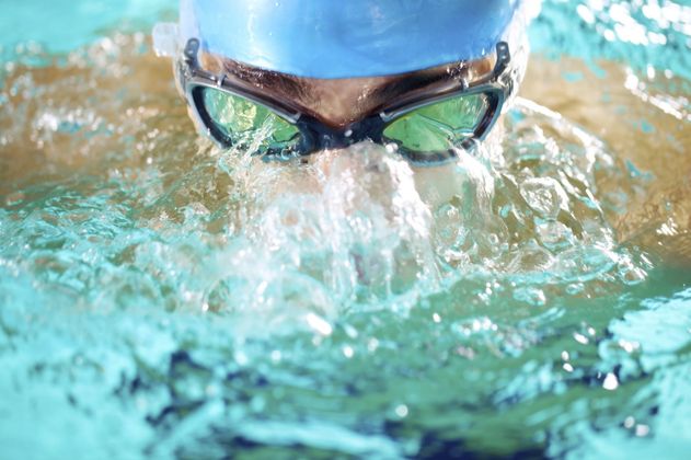 Frontalaufnahme eines Leistungsschwimmers im Wasser