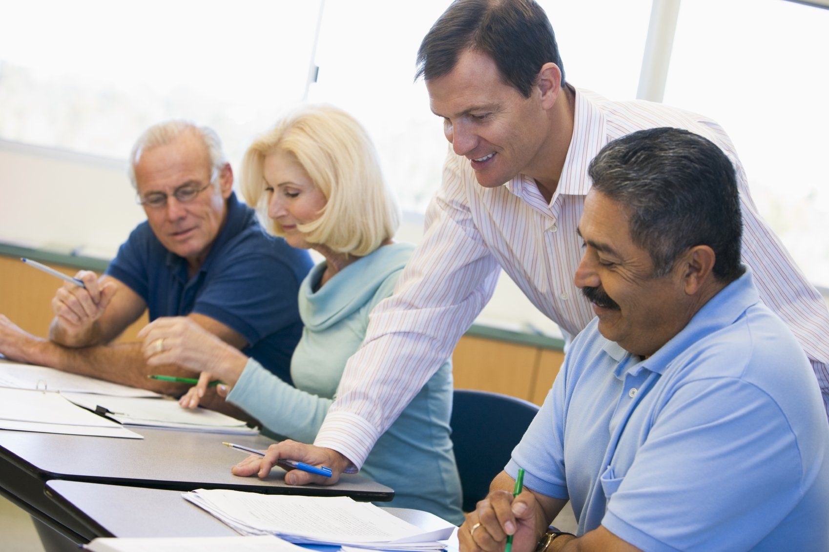 Teacher guiding adult student in class