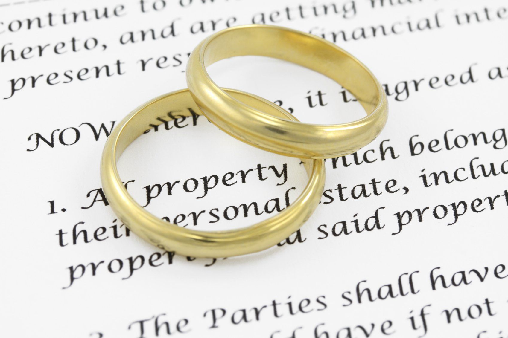 Two golden wedding rings on an Italian legal document.