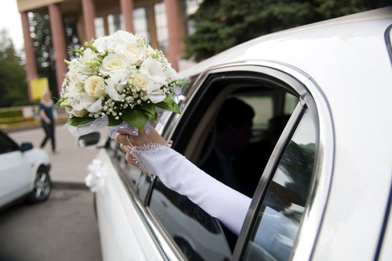 limo with brides arm holding flowers