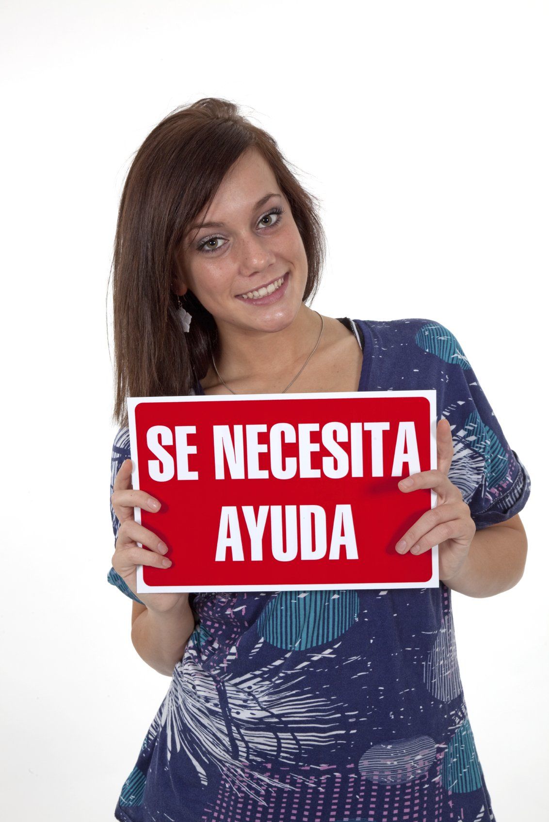 Smiling young lady, standing and holding a sign written in Spanish