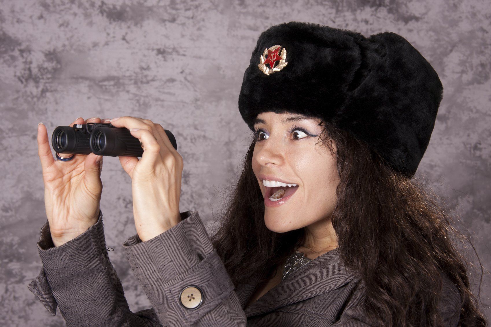 Smiling young lady about to use a pair of binoculars.