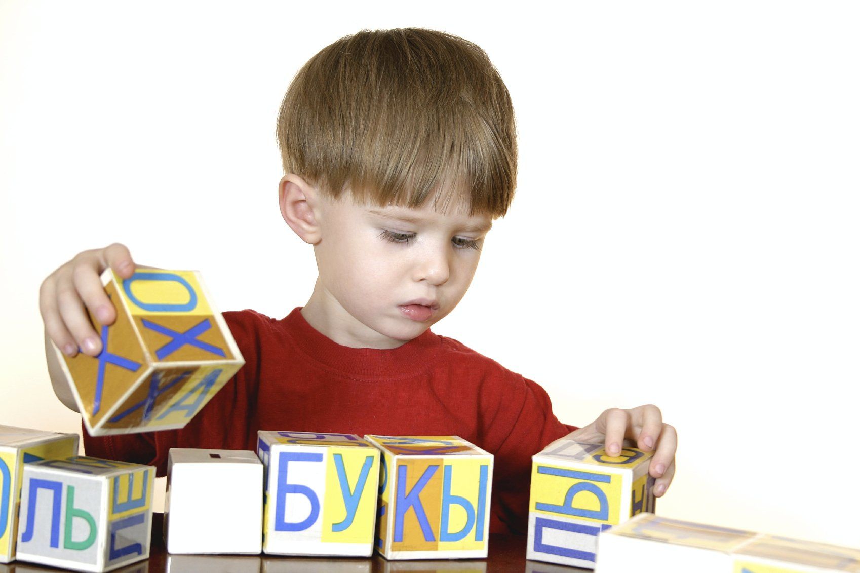 Little boy playing with a set of letter cubes