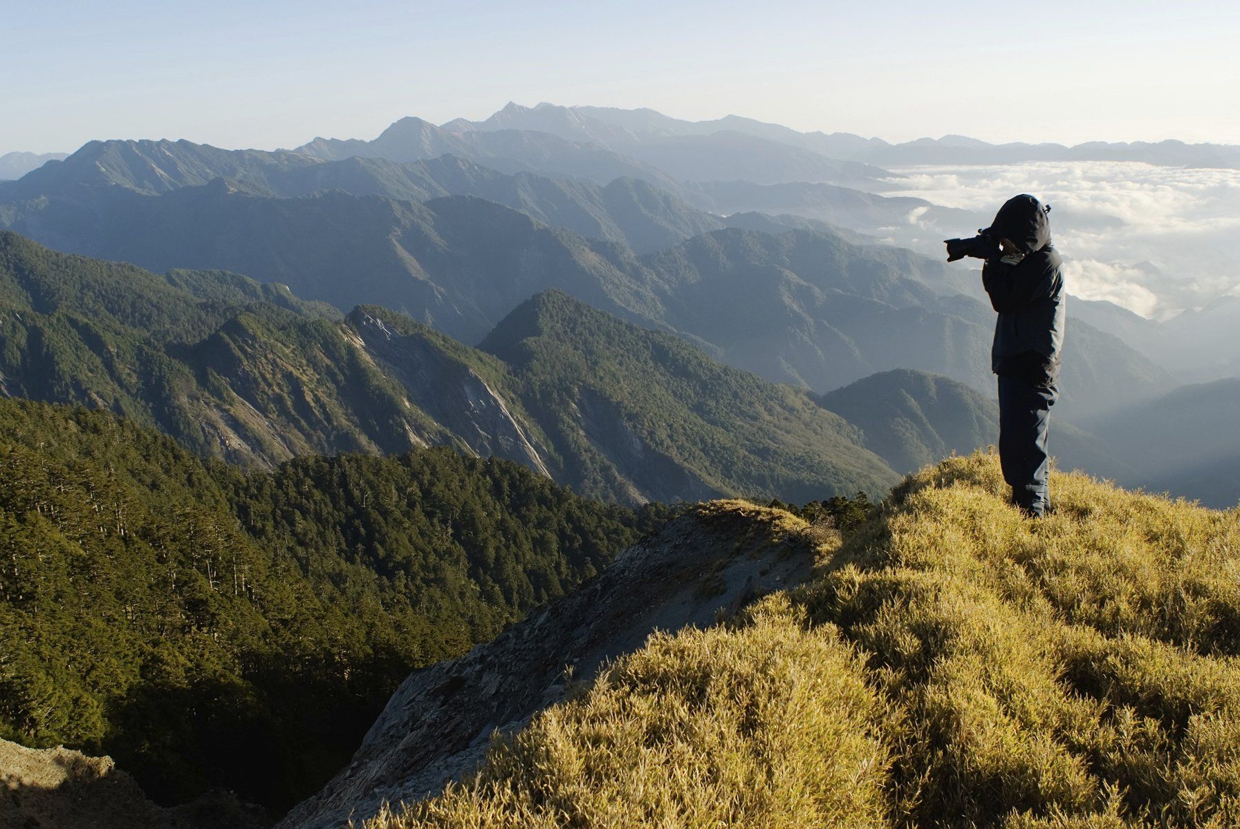 Person on a mountain taking a picture of scenery