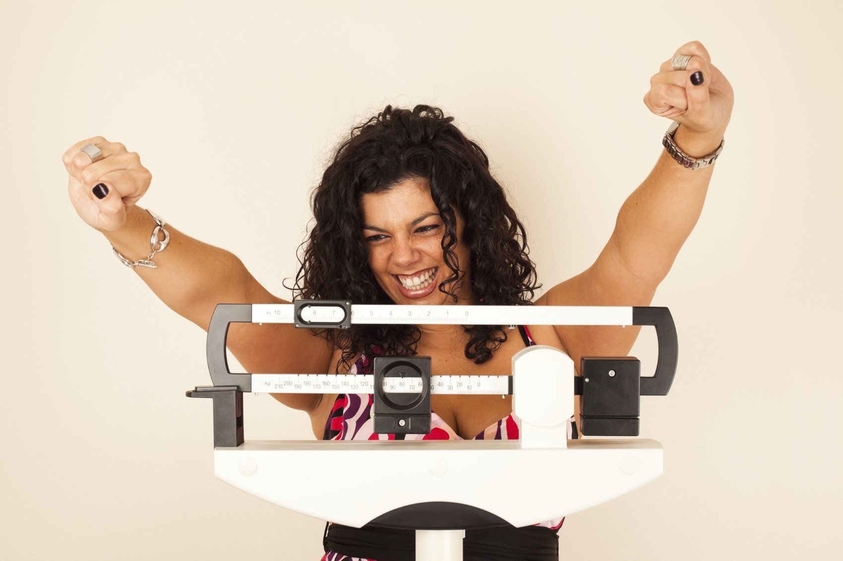 Motivierte Frau auf Waage die sich über ihren Gewichtsverlust freut