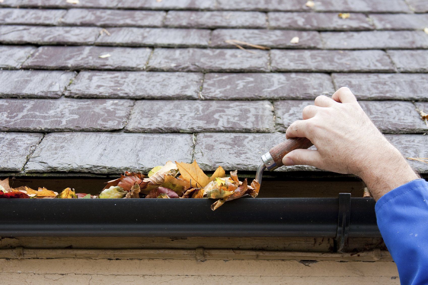 Slate roof guttering being cleared