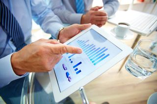 Businessman's hand pointing to data displayed on a tablet